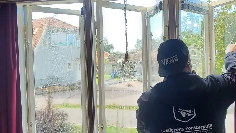 Medarbetare från Wallgrens putsar ett fönster inifrån