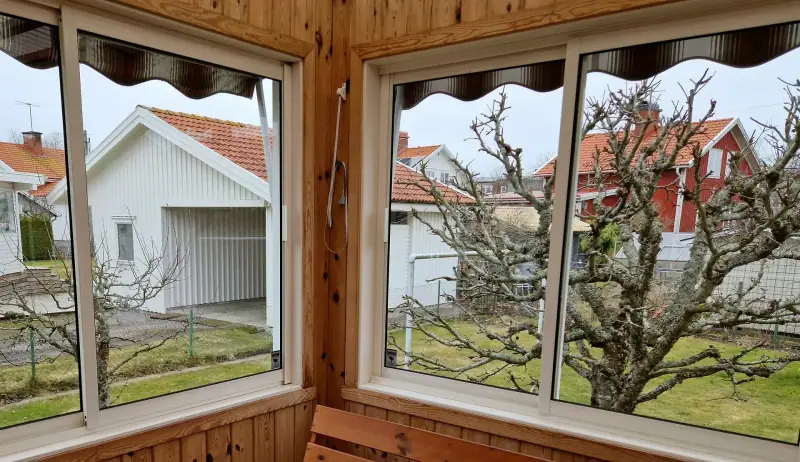 Putsade fönster i ett inglasat uterum med träpanel